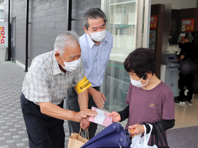 声掛けを行う安全協会メンバー（左）と黒山支店長（中）